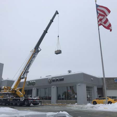 Crane lifting new HVAC unit